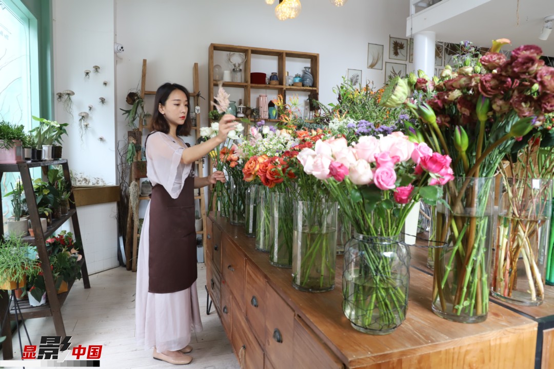 王黎媛是一名河南姑娘，在昆明念完大學(xué)后，就再也舍不下春城的藍(lán)天陽(yáng)光、青山碧水，更舍不下這里的四時(shí)繁花，于是就干脆留了下來，成了一名媒體人。2017年的時(shí)候又毅然辭去工作，創(chuàng)業(yè)開起了花店，成了都市里的一名“花房姑娘”。圖為王黎媛在自己的花店中整理鮮花。新華網(wǎng) 周亞平/攝 念新洪/文